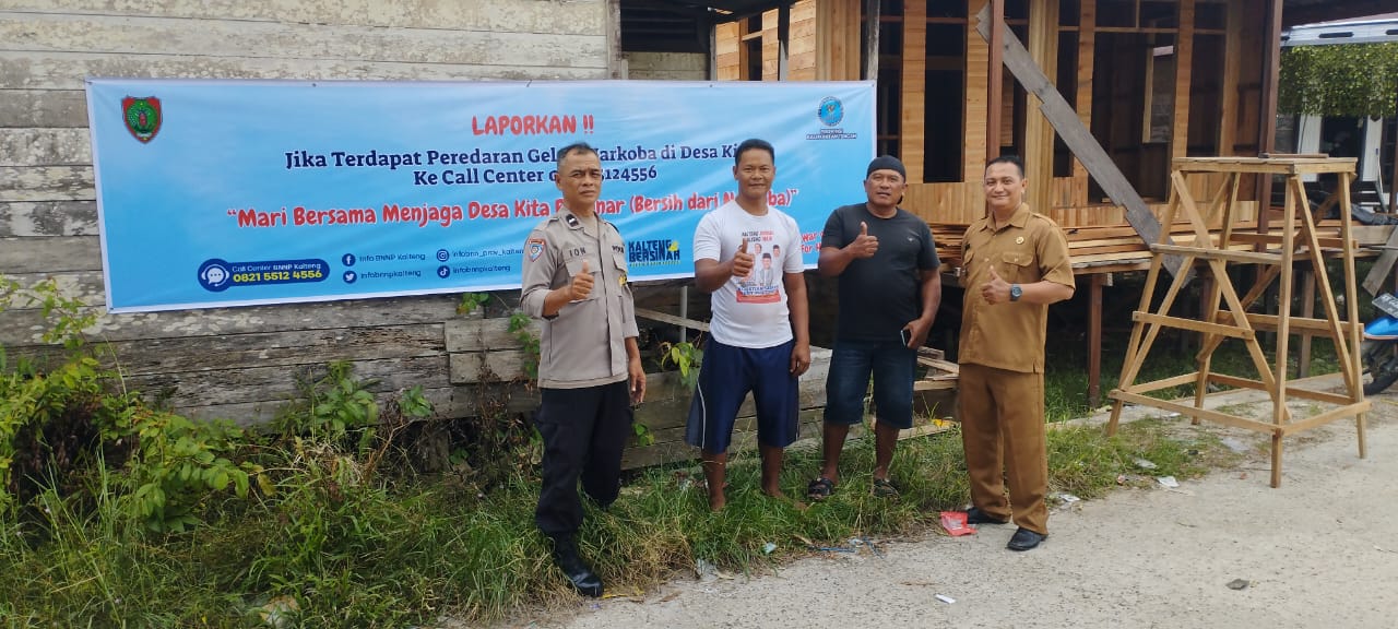 Bhabinkamtibmas Polsek Sabangau Dampingi Lurah Pasang Spanduk Anti-Narkoba di Bereng Bengkel