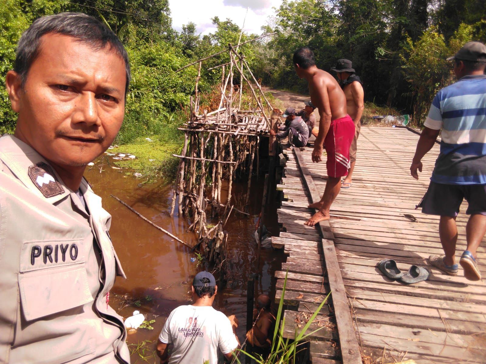 Di Sela Perbaikan Jembatan di Marang, Bhabinkamtibmas Polsek Bukit Batu Sosialisasikan Layanan Polri 110
