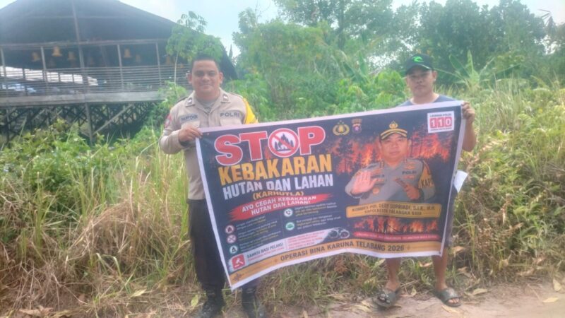 Bentangkan Spanduk di Kanarakan, Bhabinkamtibmas Polsek Bukit Batu Tanamkan Komitmen Cegah Karhutla